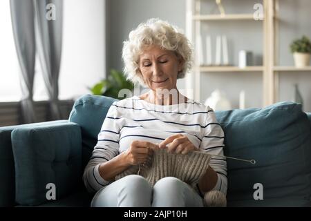 Großmutter holding Nadeln auf kitting Aktivität konzentriert Stockfoto