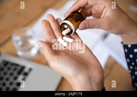 Kranke Frau gießen Pillen aus Flasche in der Hand, Nahaufnahme Stockfoto