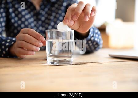 Kranke Frau drop Brausetabletten aspirin ins Wasser Glas Medizin nehmen Stockfoto