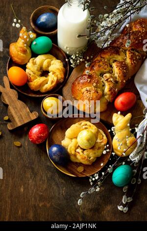 Ostern Tisch. Ostern Gebäck und gefärbten Eiern auf einem hölzernen Arbeitsplatte. Kopieren Sie Platz. Stockfoto