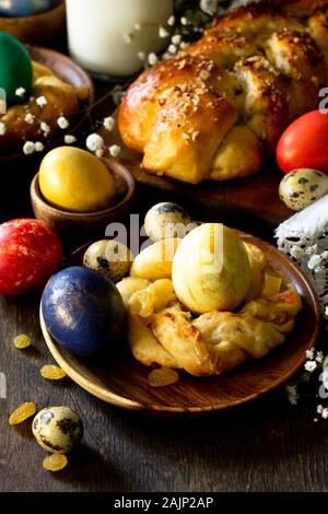 Ostern Tisch. Ostern Gebäck und gefärbten Eiern auf einem hölzernen Arbeitsplatte. Stockfoto