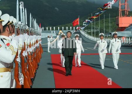 Peking, China Hainan Provinz. 17 Dez, 2019. Xi Jinping, Generalsekretär des Zentralkomitees der Kommunistischen Partei Chinas, Chinesische Präsident und Vorsitzender der Zentralen Militärkommission, Bretter der Flugzeugträger Shandong und Bewertungen die Wachen der Ehre an einen Kriegshafen in Sanya, South China Hainan Provinz, Dez. 17, 2019. Xi nahmen an der feierlichen Inbetriebnahme von Chinas erstem im Inland gebaute Flugzeugträger, der Shandong, am gleichen Tag. Credit: Li Gang/Xinhua/Alamy leben Nachrichten Stockfoto