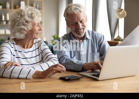 Ältere Paare mit Laptop und online banking Zufrieden Stockfoto