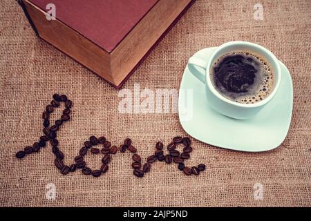 Ein vintage Bild zeigt die Liebe mit Kaffeebohnen und einer Tasse Kaffee Stockfoto