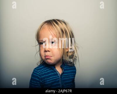 Studio Portrait von Toddler Gesichter ziehen Stockfoto