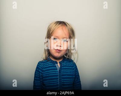 Studio Portrait von Toddler Gesichter ziehen Stockfoto