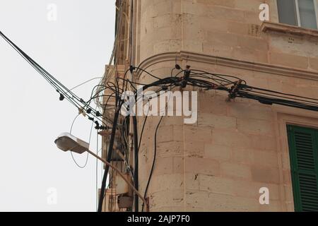 Unordentliche elektrische Leitungen an der Wall Ecke in Malta Stockfoto