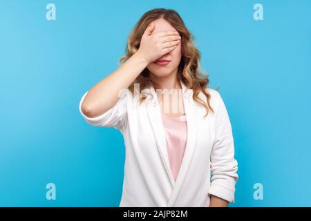 Möchten nicht zu sehen. Portrait von umgekippt Frau mit gewelltes Haar in weisse Jacke, die Augen mit der Hand, versteckt aus Angst, verärgert und verängstigt expressio Stockfoto