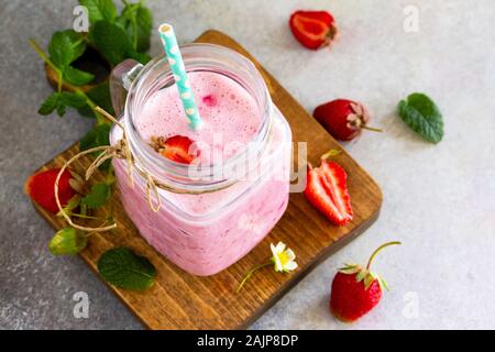 Erdbeere Obst Joghurt Smoothie oder Milch Shake in Glas Glas auf einem Holztisch. Natürliche Entgiftung, Obst, Dessert, gesunde Diät Konzept. Stockfoto