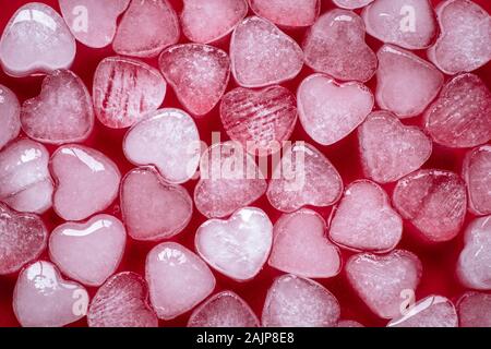 Herz aus Eis. Herz geformten Süßigkeiten. Red Grußkarte der Valentinstag. Symbol der Liebe und der Romantik. Romantische Hintergrund, Textur, Muster Stockfoto