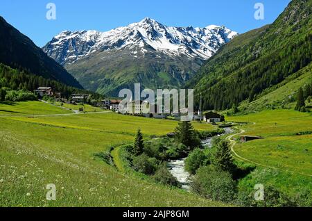 Plangeross, Österreich - 23. Juni 2016: Kleines Dorf in Pitztal mit verschneiten Tiroler Alpen im Hintergrund, bevorzugte Gegend für Skifahren und Wandern Stockfoto