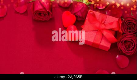 Valentinstag Geschenk. Rosen und roter Geschenkbox auf Stoff Textur Stockfoto