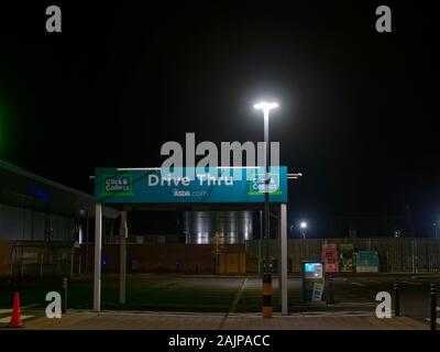 Die Stille und Leere kleine Drive Thru Vordach und der Bereich des ASDA Supermarkt in Forfar am Tag der neuen Jahre Abend. Stockfoto