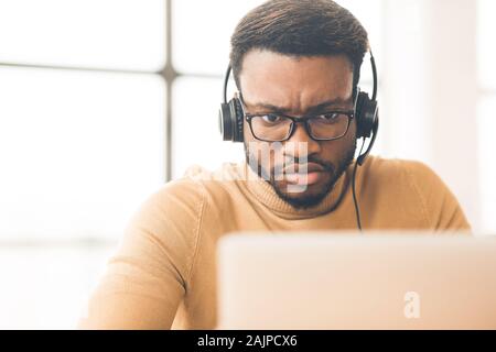 Tech Support. Konzentriert schwarze männliche helpline Operator in das Arbeiten mit der Sprechgarnitur in Customer Care support Office, kopieren Raum Stockfoto