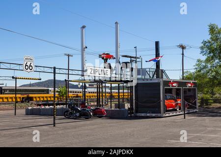 William, Arizona, USA - 01. Juni 2015: Kunst Installation im Zentrum der Stadt, Zipline. Autos und Motorräder. Der Grand Canyon im Hintergrund. Stockfoto