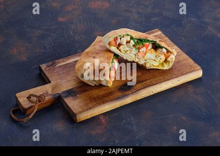 Fladenbrot gefüllt mit Hähnchen, Tomaten und Omelette Stockfoto