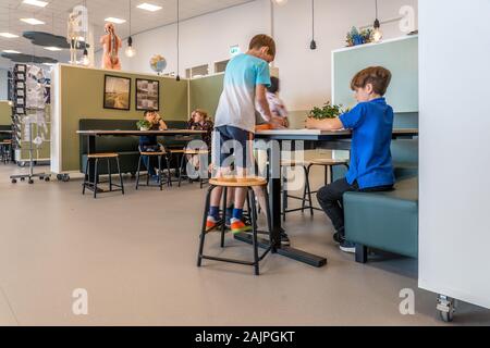 NIJMEGEN/Niederlande - September 13, 2019: Junge Kinder spielen miteinander in der Schule und saß an einem Tisch Stockfoto