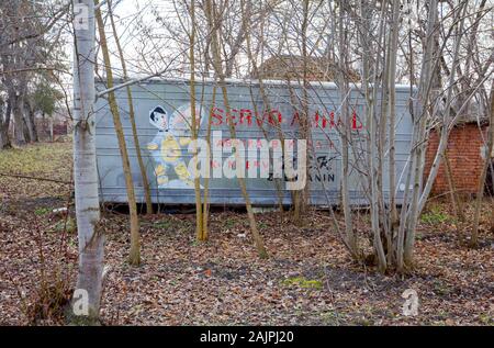 Zrenjanin, Vojvodina, Serbien - 20. Februar 2019: aufgegeben und veraltete Cold Storage aus rostfreiem Blech in Bäumen bewachsen. Logo Zeichen Stockfoto