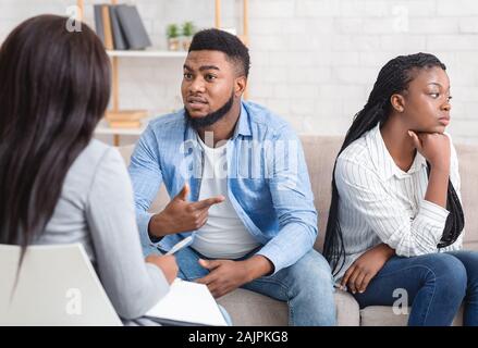 Afro Mann Teilen Familie Probleme beim Sitzen Neben seinem beleidigt Frau an den Ratgeber Büro, selektiven Fokus Stockfoto