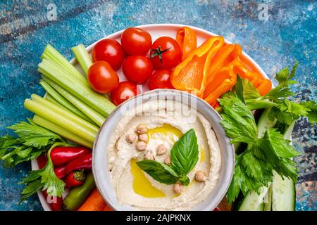 Hummus platter mit verschiedenen Snacks. Hummus in der Schüssel und Gemüse Sticks. Platte mit dem Nahen Osten. Partei, Finger Food. Ansicht von oben. Vegan, Hummus dip Stockfoto