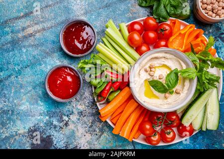 Hummus platter mit verschiedenen Snacks. Hummus in der Schüssel und Gemüse Sticks. Platte mit dem Nahen Osten. Partei, Finger Food. Ansicht von oben. Vegan, Hummus dip Stockfoto