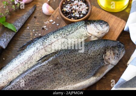 Frische rohe Forelle Fisch und Gurke Zutaten auf einem Holztisch. Kochen Fisch Vorbereitung. Stockfoto