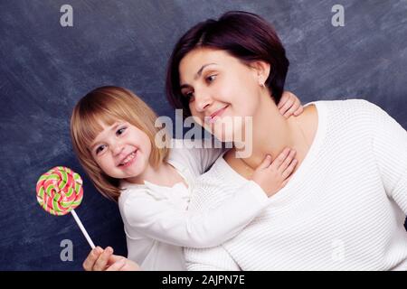 Mama gibt Ihr smiling baby ein süßes Süßigkeit Stockfoto