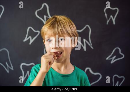 Litle kaukasischen Junge hält einen fallengelassen Milchzahn zwischen seinen Fingern und lacht in die Kamera Stockfoto