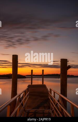 Eine motion blur Bild von einem Bootsanleger, in Daytona Beach, Florida bei Sonnenaufgang auf dem Halifax River entfernt. Stockfoto