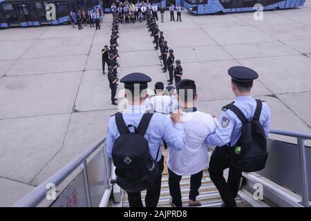 (200105) - Peking, Januar 5, 2020 (Xinhua) - die Polizeieskorte ein Telecom Betrug vermuten, zum internationalen Flughafen der Hauptstadt in Peking, der Hauptstadt von China, 7. Juni 2019. Eine Gruppe von 94 Verdächtigen, von der Chinesischen Polizei eskortiert, Waren aus Spanien nach Peking am Morgen des 7. Juni, 2019 geflogen, die erste Lieferung von chinesischen Telecom Betrug vermutet auf dieser Skala von Europa. (Xinhua / Yin Schleifring) Stockfoto