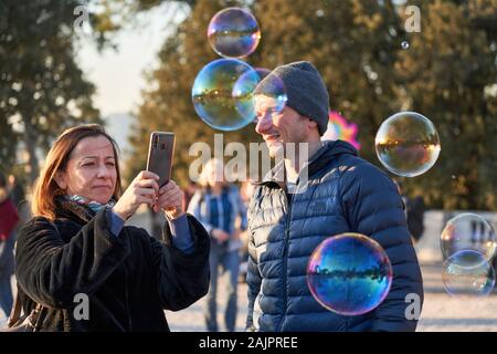 Rom, Italien, 1. Januar 2020: Einheimische und Touristen spielen bei Sonnenuntergang mit traditionellen Seifenblasen in Pincio Terrasse im Winter Urlaub Stockfoto