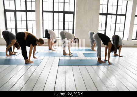 Vielfältige sportliche Menschen üben Yoga, vorwärts tun bend Übung Stockfoto