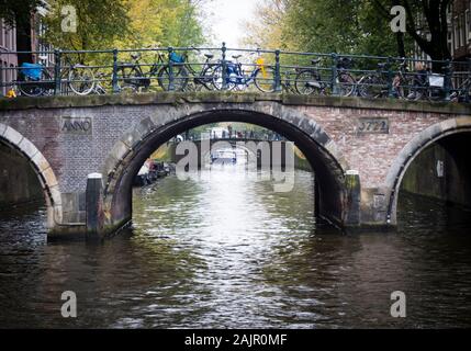 Abgestellte Fahrräder auf einem alten Amsterdam Canal Brücke über Reguliersgracht im historischen Zentrum der Stadt. Stockfoto