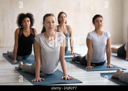 Diverse Frauen, cobra Übung in Gruppe Lektion, Yoga Stockfoto