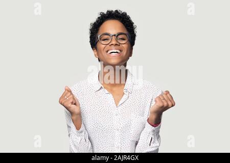 Afrikanische Frau geballten Fäusten glücklich fühlt sich feiert Erfolg studio Shot Stockfoto