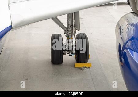Keile um die Räder des Fahrwerks eines Airbus A319. Sie verhindern, dass das Flugzeug von Rollen in den Wind. Stockfoto
