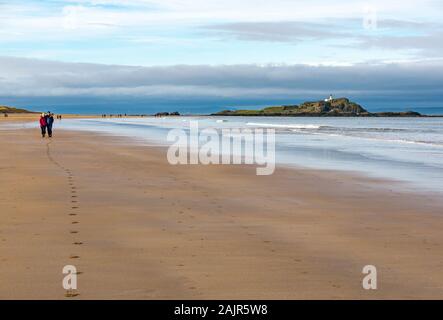 East Lothian, Schottland, Großbritannien. Januar 2019. UK Wetter: Sonnenschein entlang der Küste ist ideal für Outdoor-Wintersport. Bei Ebbe am Yellowcraig wandern die Menschen am breiten Strand mit Fidra Island am Horizont im Firth of Forth Stockfoto