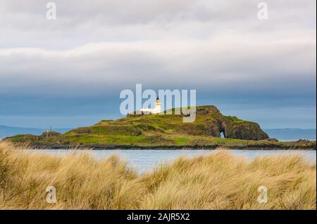 East Lothian, Schottland, Großbritannien. Januar 2019. UK Wetter: Sonnenschein entlang der Küste. Der Leuchtturm auf Fidra Island scheint in der Sonne im Firth of Forth vom Yellowcraig Strand aus gesehen Stockfoto