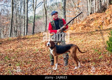 Jäger mit Waffe Jagd und Hund jagen im Wald Stockfoto