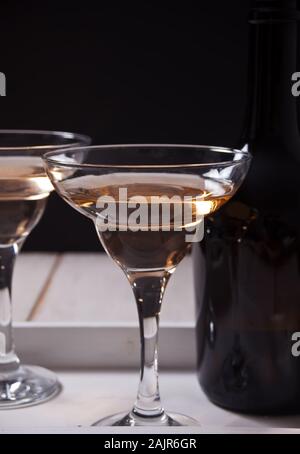 Weißwein in eine Brille, Flasche auf dem weißen Holz- fach Romantisches Abendessen für Zwei Stockfoto