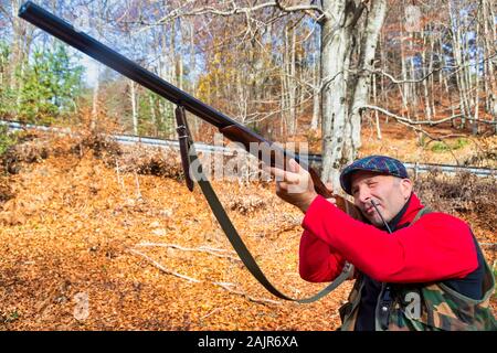 Jäger mit Waffe jagen im Wald Stockfoto