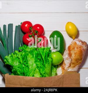 Paper bag verschiedener Gesundheit Nahrung auf weißem Holz- Hintergrund. Ansicht von oben Stockfoto