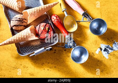 Wafer Kegel und Eis Schaufeln mit zwei verschiedene Geschmacksrichtungen cremig italienisches Eis in einer flachen gesehen lag noch Leben Stockfoto