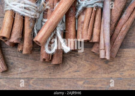 Zimtstangen und Mahlzeit schließen bis auf Holz- Hintergrund. Weihnachten dekorative Grenze von zimtstangen Gewürz. Ansicht von oben. Stockfoto