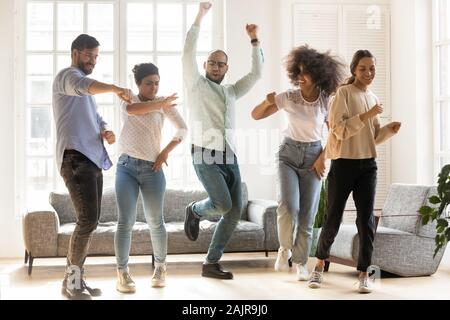Überglücklich multirassischen junge Leute zusammen tanzen im Innenbereich Stockfoto