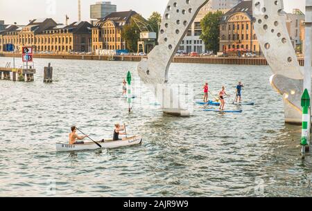 Stand-up-Paddler und kanuten vorbei unter dem großen Skulptur Molecule Man Stockfoto