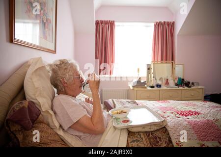 83 Jahre ältere Frau, ihr Mittagessen alleine Essen im Bett, England, Vereinigtes Königreich Stockfoto