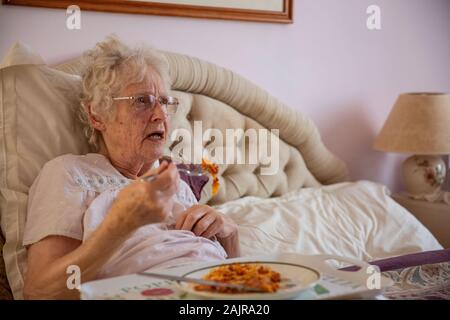 83 Jahre ältere Frau, ihr Mittagessen alleine Essen im Bett, England, Vereinigtes Königreich Stockfoto