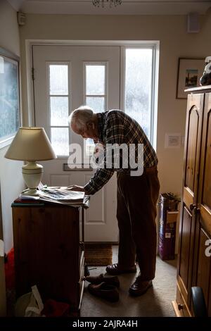 87 Jahre alte ältere Menschen, die allein leben, in seinem Flur, England, Vereinigtes Königreich Stockfoto