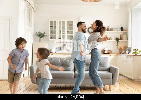 Familie tanzen im Wohnzimmer fühlt sich glücklich Urlaub genießen Stockfoto